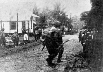 Japanese paratroopers carefully advancing through the streets of Menado, January 1942